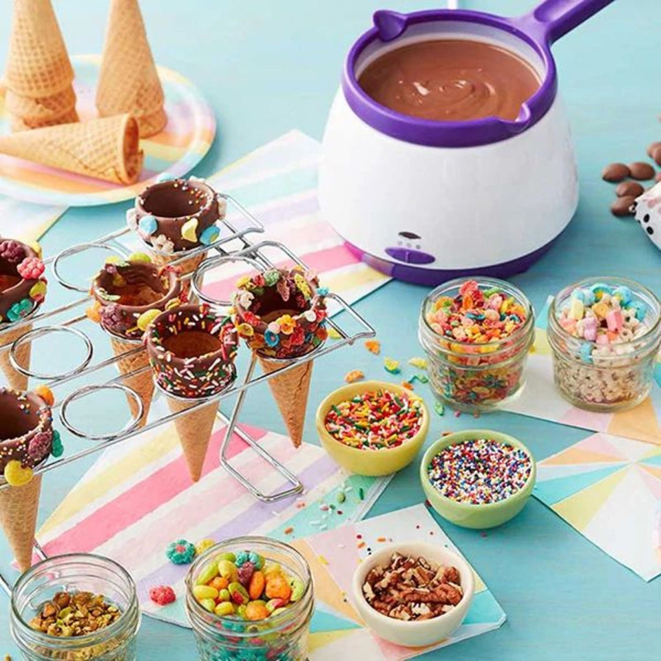 Chocolate melting pot with decorated ice cream cones and toppings