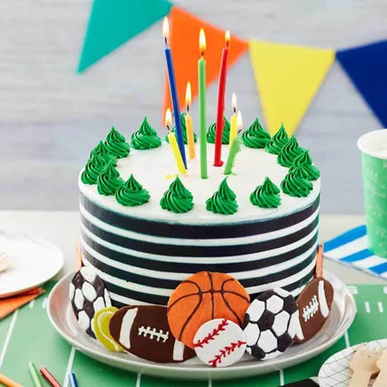 Buttercream striped cake with candles and colorful party decorations